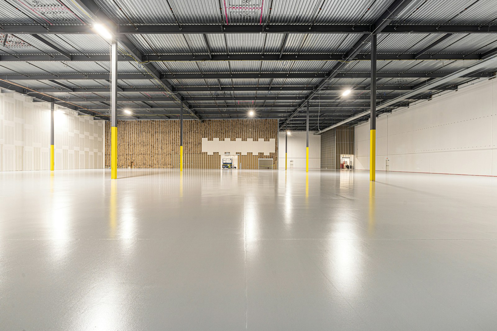 An empty industrial unit with a freshly ground and sealed concrete floor.